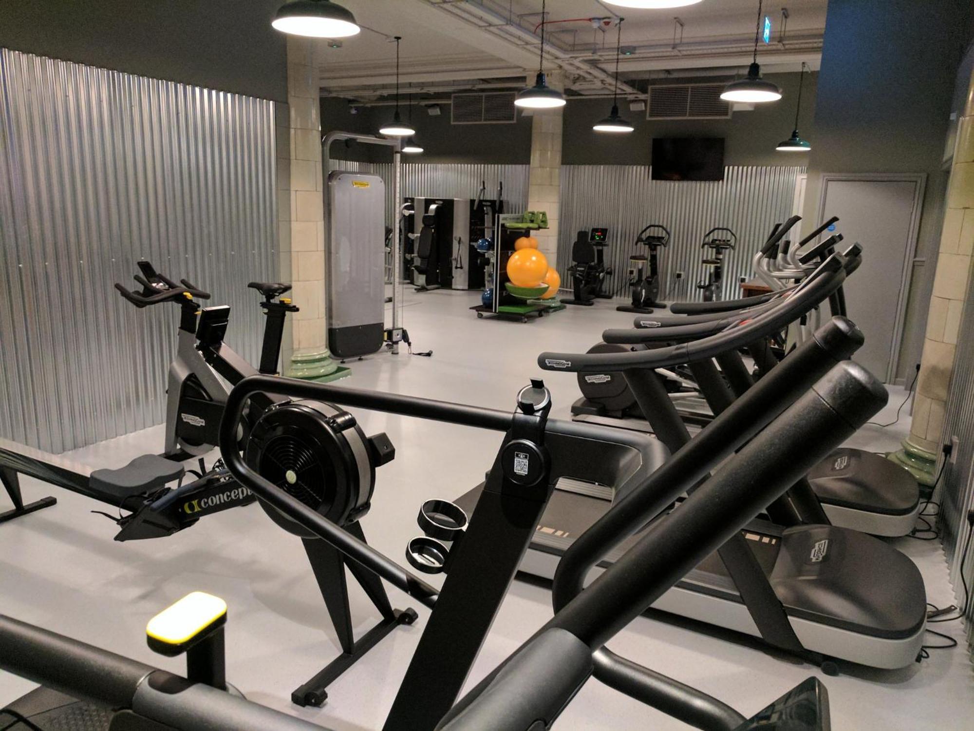 Kimpton Clocktower By Ihg Otel Manchester Dış mekan fotoğraf The photo shows an indoor gym or fitness center. It features various exercise equipment, including:

- Treadmills and elliptical machines lined up in the foreground.
- A rowing machine is visible on the left.
- In the background, there are weight mac