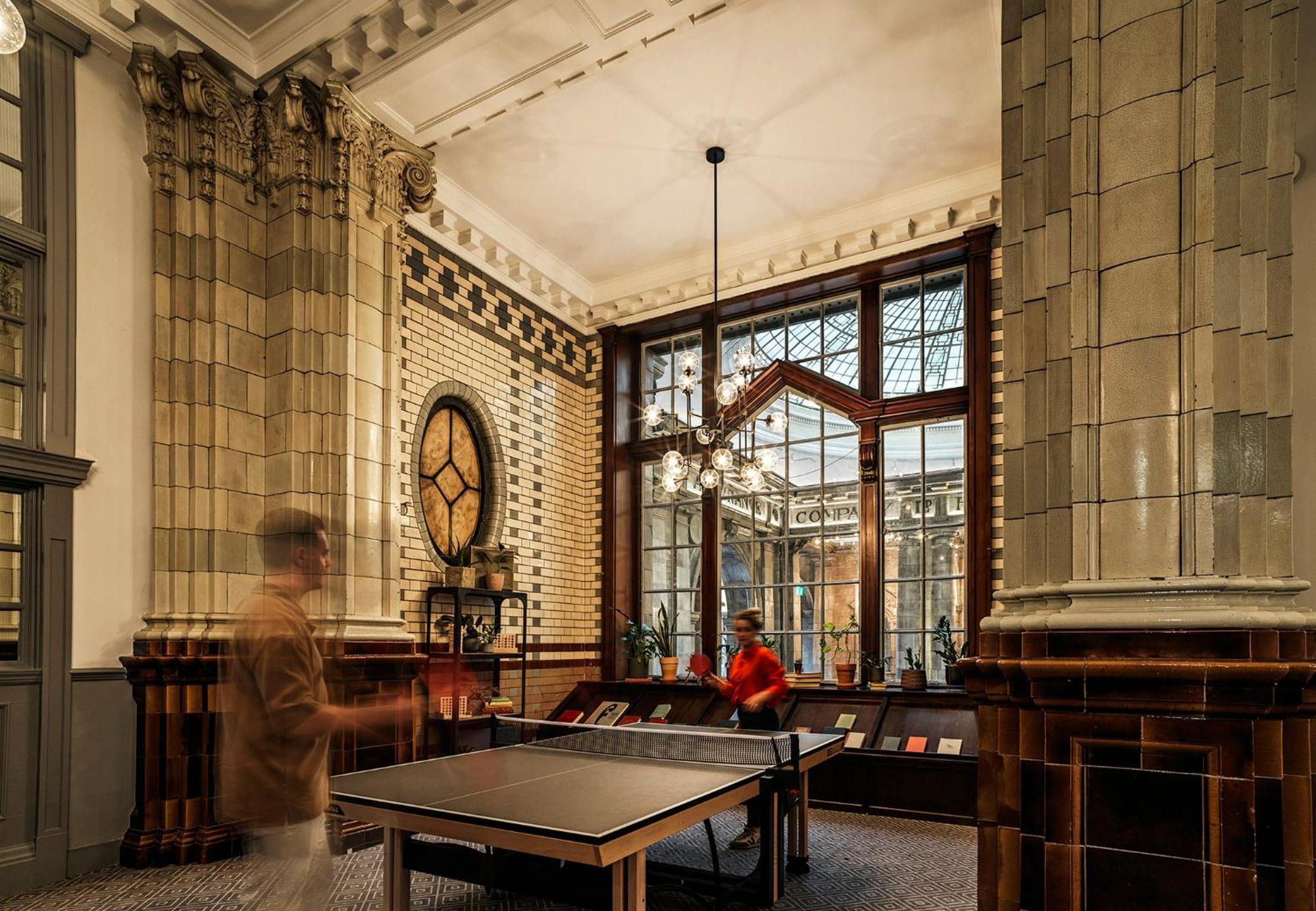 Kimpton Clocktower By Ihg Otel Manchester Dış mekan fotoğraf The photo depicts an elegant indoor space characterized by high ceilings and ornate architectural details. There are large windows that allow natural light to flood in, highlighting the decorative tile work and a mix of classic and modern furnishings
